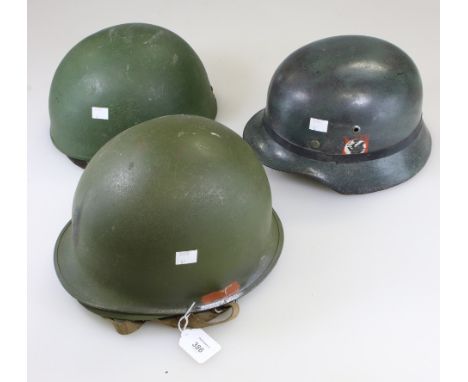 A German M40 type steel helmet, with SS and Nazi swastika decals, together with a paratroopers helmet and an American Vietnam