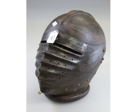 A late 16th century-style closed iron helmet, with hinged face guard, 30cm high