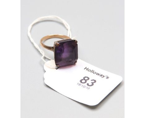 A single stone amethyst dress ring, rectangular cut cornered step cut stone, in raised basket mount