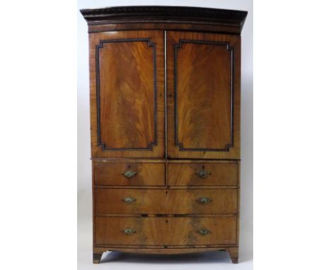 An early 19th Century mahogany bowfront linen press cabinetWith moulded cornice, over a top section with two panelled doors, 