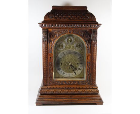 A late 19th Century bracket clockThe arched brass and silvered face with circular dial with Arabic and Roman numerals and thr