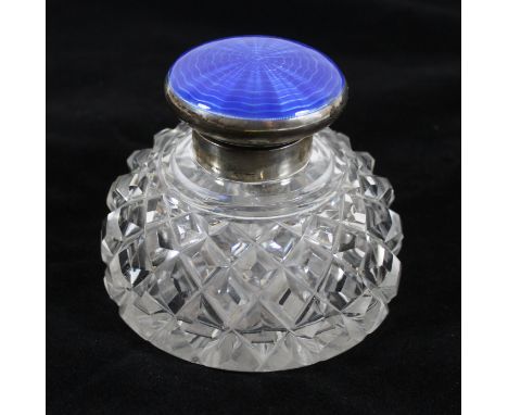 An early 20th Century silver and enamel lidded inkwellThe glass inkwell with silver collar and blue engine turned enamel hing
