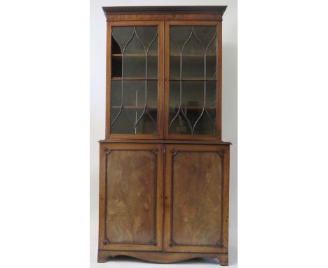 A 19th Century mahogany bookcase cabinetThe top section with dentil cornice over two glazed doors and a shelved interior, the