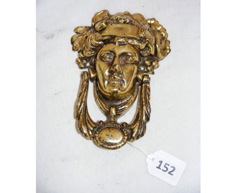 A vintage brass door knocker in the form a lady. 