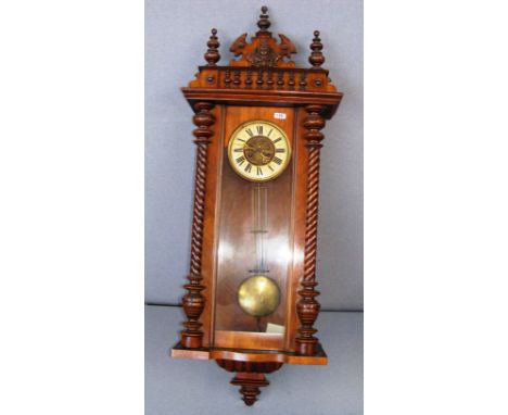 A large mahogany Vienna wall clock with twisted columns with a carved figural central finial and two turned finial's either s