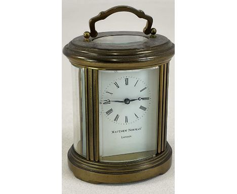 MATTHEW NORMAN; an oval brass carriage clock, with Roman numerals to the signed dial, and receipt when purchased in 1982 for 