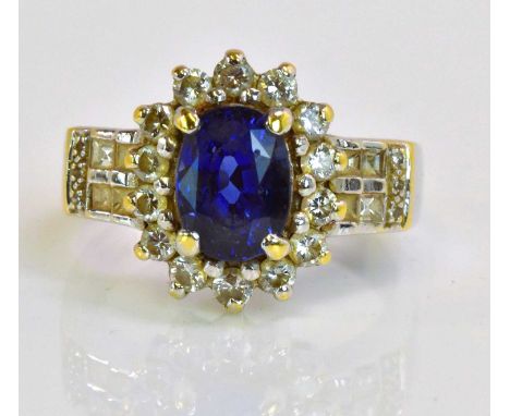 An impressive 18ct white gold sapphire and diamond oval floral cluster ring, centred with a four claw set sapphire within a f