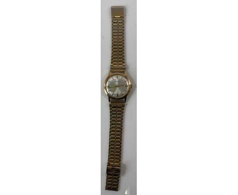 GARRARD; a gentleman's vintage 9ct yellow gold wristwatch, with baton markers to the circular dial, the case back with presen