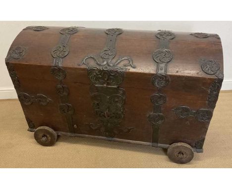A 19th century Indian teak and metal mounted domed trunk on wheels, length 121cm
