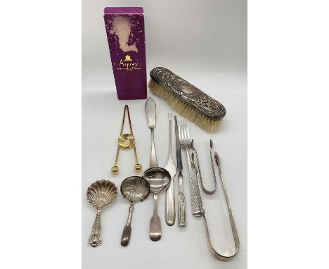 A group of small silver comprising two pairs of sugar tongs, a fork and a caddy spoon, combined approx 3.48ozt/108.1g, also a