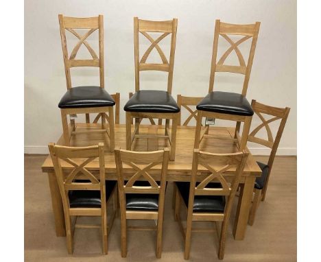 OAK FURNITURE LAND; a solid light oak table, 78 x 180 x 90cm unextended, 280 cm extended, and ten chairs with faux leather pa