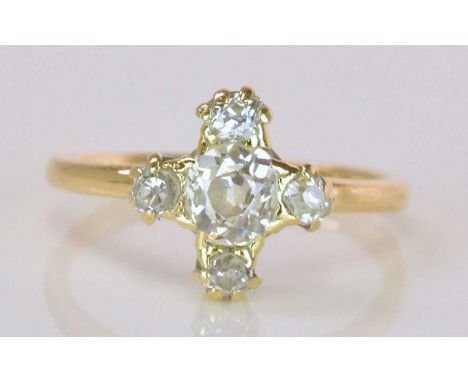 A yellow metal diamond set cross ring, the central old cut diamond weighing approx 0.40ct, with four further diamonds to the 