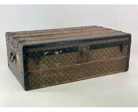 LOUIS VUITTON; an early 20th century strap bound travelling trunk, with monogrammed detail throughout, numbered 212379, with 