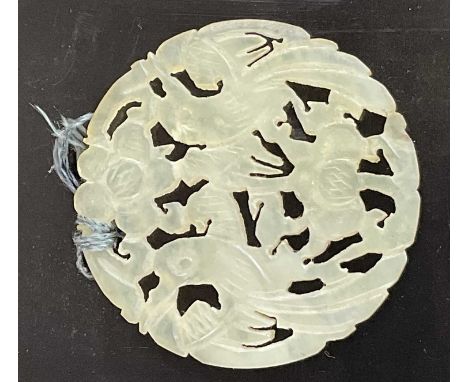 A Chinese celadon jade coloured circular pendant, carved with two birds beside flower heads, width 54mm.