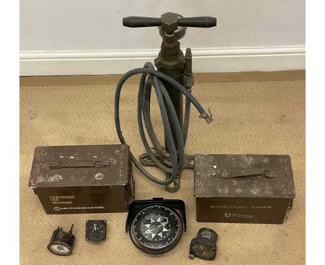 A small collection of military equipment, consisting of three aircraft gauges, two ammunition containers, a nautical compass 