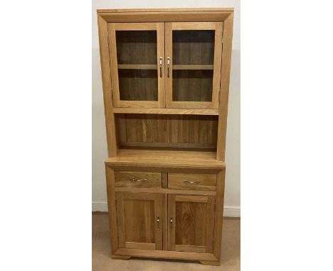 OAK FURNITURE LAND; a light oak cabinet, the base unit with two drawers over cupboard, the top unit with two shelves with gla