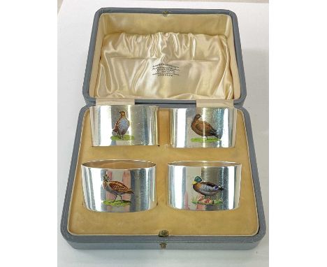 CHARLES PERRY &amp; CO; a good set of four George V hallmarked silver and enamel decorated napkin rings, each decorated with 