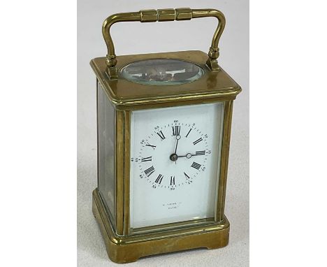 A circa 1900 brass carriage clock, with swing loop handle and Roman numerals to the white enamel dial, indistinctly signed 'P