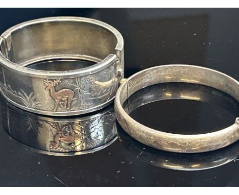 Silver bangle together with a white metal bangle embossed with gold deer Total weight 50g 