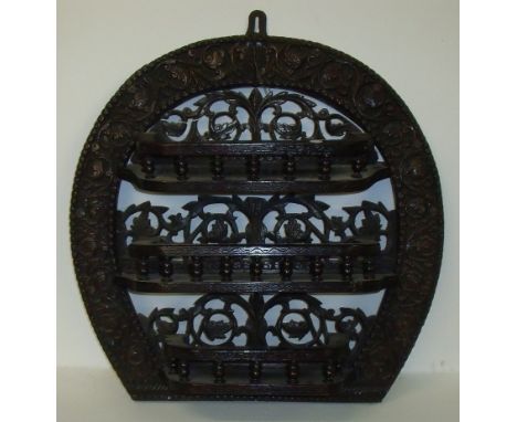 Early 20th C elaborately carved oak wall shelf with horseshoe shaped back and three galleried shelves with carved and  pierce