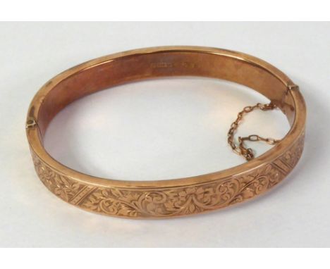 EDWARDIAN 9ct GOLD HINGE OPENING HOLLOW BANGLE, the top foliate scroll engraved, Chester hallmarked 1909, 9gms, in original m