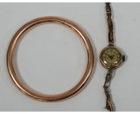 9ct GOLD HOLLOW SLAVE BANGLE, 13.2gms and a LADY'S 9ct GOLD WRIST WATCH, Swiss 15 jewel movement with silvered circular Arabi