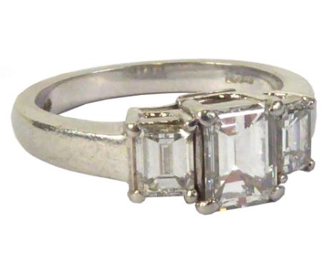 PLATINUM RING, SET WITH AN EMERALD CUT SOLITAIRE DIAMOND, and with an emerald cut diamond to each shoulder, the centre emeral