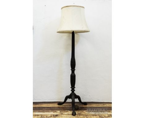 An ebonised standard lamp with fluted and turned column, on tripod base supported by ball and claw feet