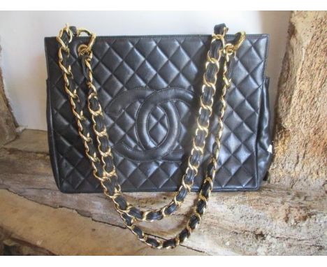 A  modern black leather padded shoulder bag with chain loop shoulder straps, in the style of a well known fashion house 