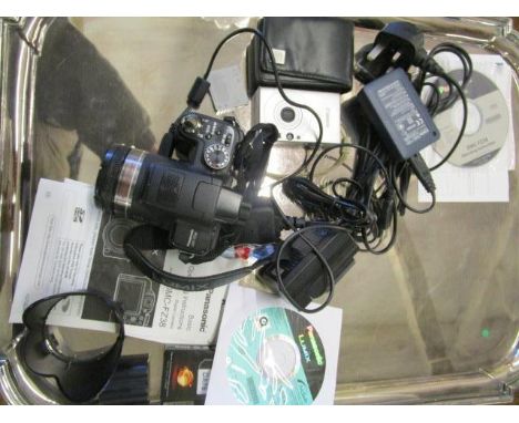 A Panasonic digital camera model no DMC F238 with software, operating instructions and accessories, and a Canon digital 1xUS7