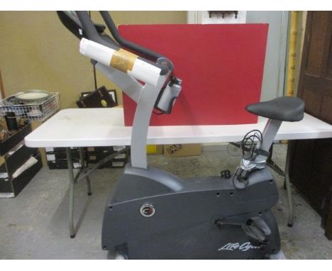 A LifeFitness indoor electric static bike with instruction manual and heart rate monitor chest band 