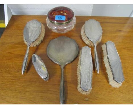 A five piece silver backed dressing table set with engine turned decoration, a silver lidded glass jar and a faux tortoiseshe