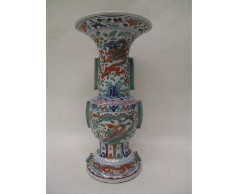 A 20th century Chinese 18th century style Gu vase with a flared neck and foot decorated with panels of dragons, leaves, flowe