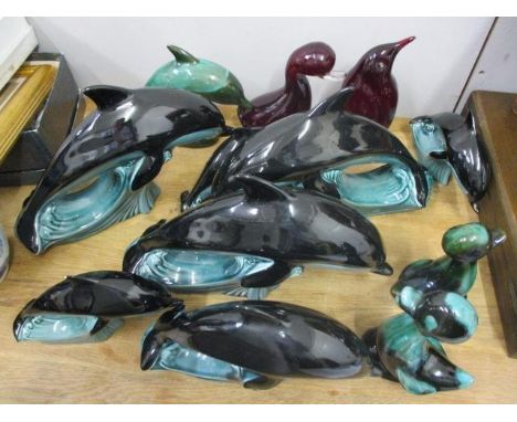 Seven Poole pottery model dolphins, a Whitefriars red glass model duck, a penguin, Canada model ducks and a dolphin 