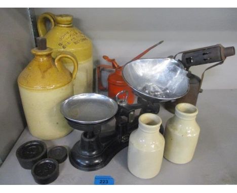 A mixed lot to include stoneware flagons, oil cans, weighing scales and other items 