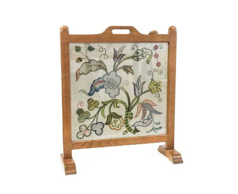 Workshop of Robert Mouseman Thompson (Kilburn): An English Oak Fire Screen, the frame inset with a woolwork floral panel, wit