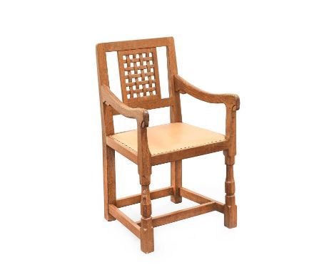 Workshop of Robert Mouseman Thompson (Kilburn): An English Oak Lattice Back Arm Chair, tan leather upholstered seat, on octag