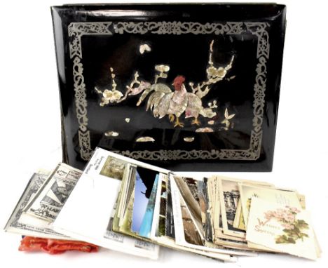 An early 20th century black lacquer photograph album with mother of pearl chicken and prunus blossom to the front, each page 