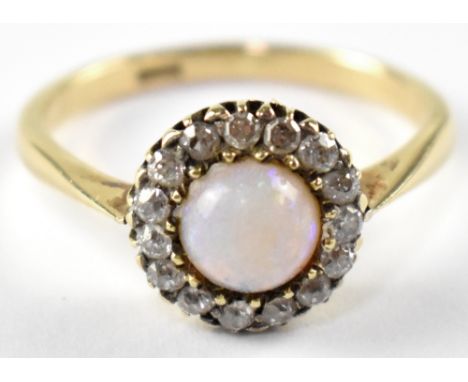 An 18ct gold diamond and opal cluster ring, a half round opal surrounded with a ring of fifteen tiny diamonds, size M, approx