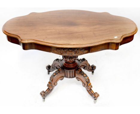 An late 19th century walnut centre table of small proportions, the shaped top with opposing frieze drawer with carved foliate