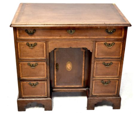 A George III mahogany kneehole writing desk with string inlaid lift-up top enclosing a multi-section fitted interior, many se