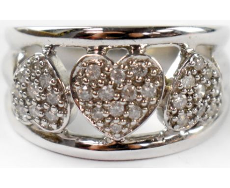 A modern 9ct gold diamond love heart ring, the head with three alternate diamond encrusted hearts on an open frame, on a hall