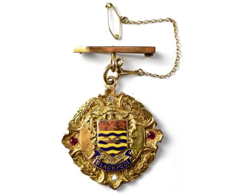 A 9ct yellow gold enamelled and jewelled medal, raised letters to the base 'Progress' and blue and gold enamelled 'Blackpool'