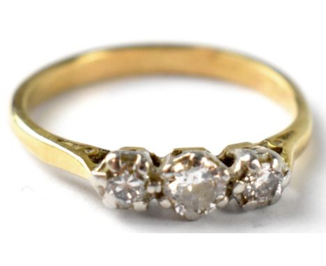 A yellow metal diamond ring with three claw set brilliant cut diamonds, the central diamond approx 0.02ct, flanked by two sma