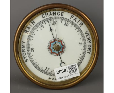Early 20th century brass cased aneroid Barometer, ceramic dial painted with a geometric centre, D13cm   Condition Report   Cl