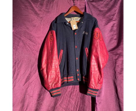 Vintage varsity jacket with red leather sleeves and a navy blue wool body. It has an embroidered name "Bobby," the number '00