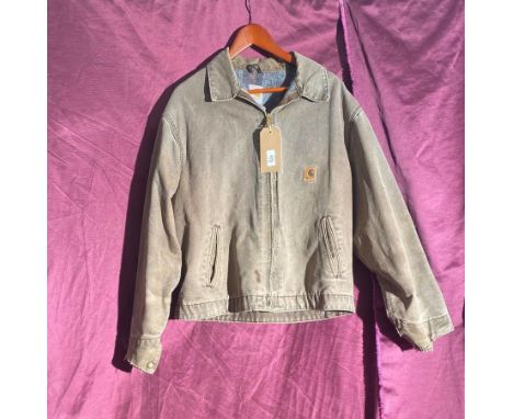 Carhartt canvas jacket, features a front zipper closure, soft lining, two side pockets, and a signature Carhartt logo patch o