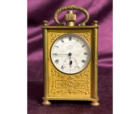 A small brass carriage clock with paperwork. Damaged case. Measures 9cm high  / All lots are located at The Barn, Hampstead F