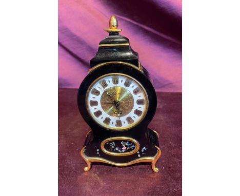 Mid 20th century black enamel mantel clock with floral accents, Roman numeral dial, and gold trim detailing.   / All lots are