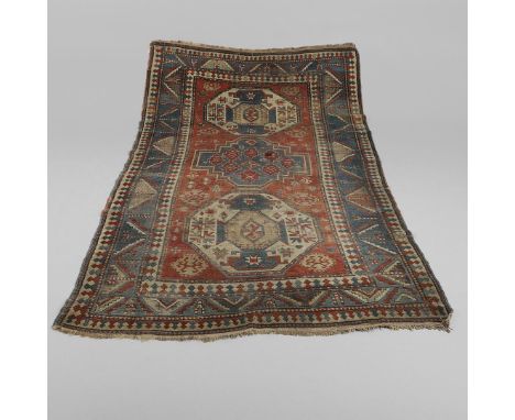 the madder field with two octagons and a medallion framed by pale indigo borders of angular stepped leaf and calyx design fla